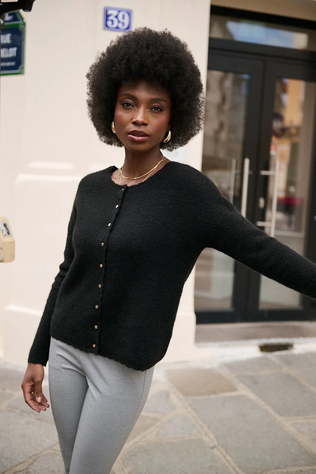 Mannequin portant le gilet Bruna noir, encolure ronde et boutons dorés