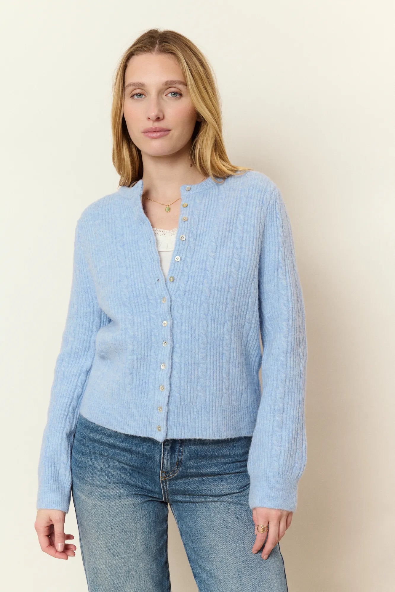 Cardigan bleu ciel en alpaga et laine mélangés à torsades fantaisie, encolure ronde et boutons en nacre. Une maille douce et chaleureuse au quotidien.