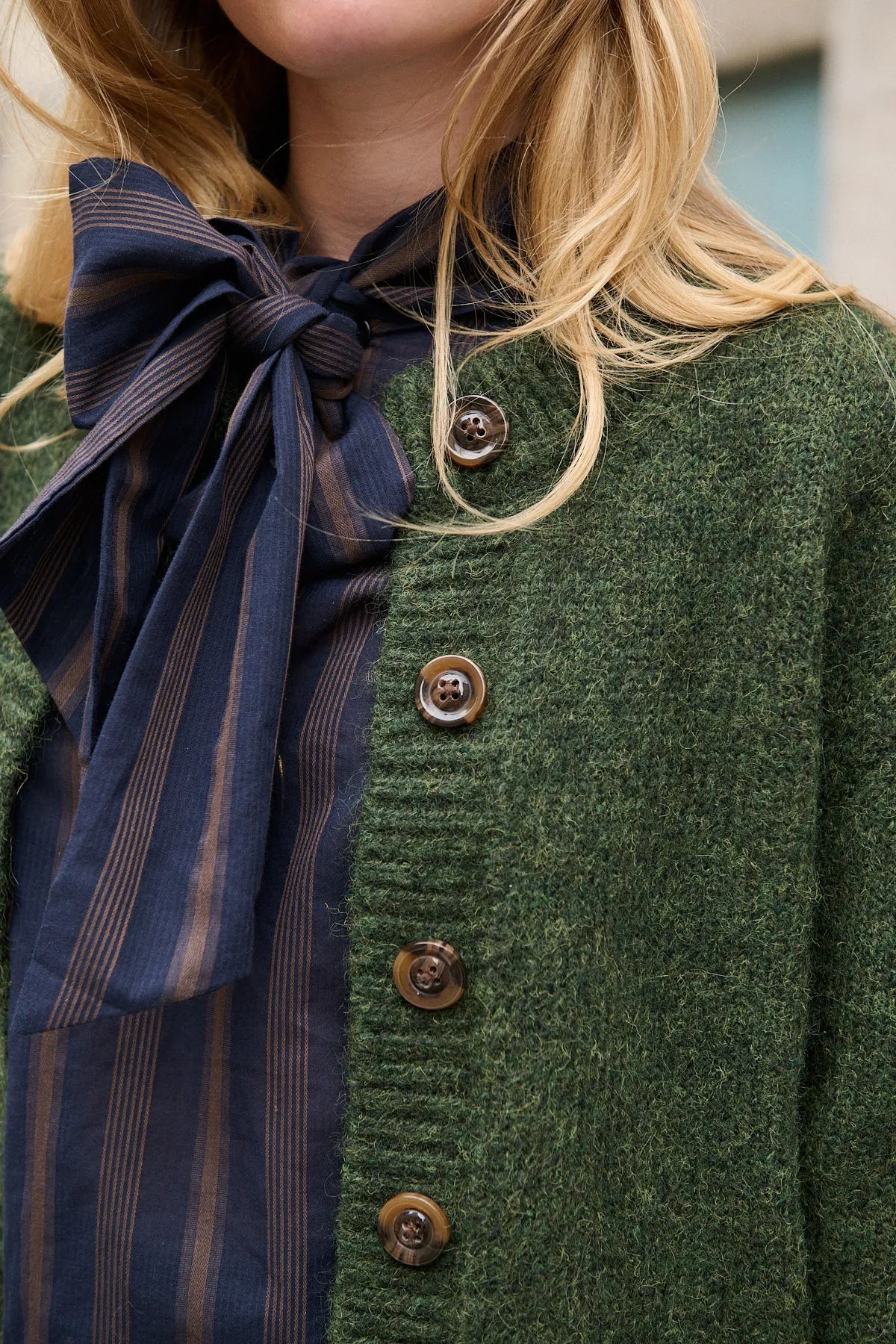 Détail du volume des manches et de l'encolure montante du cardigan Gabin olive