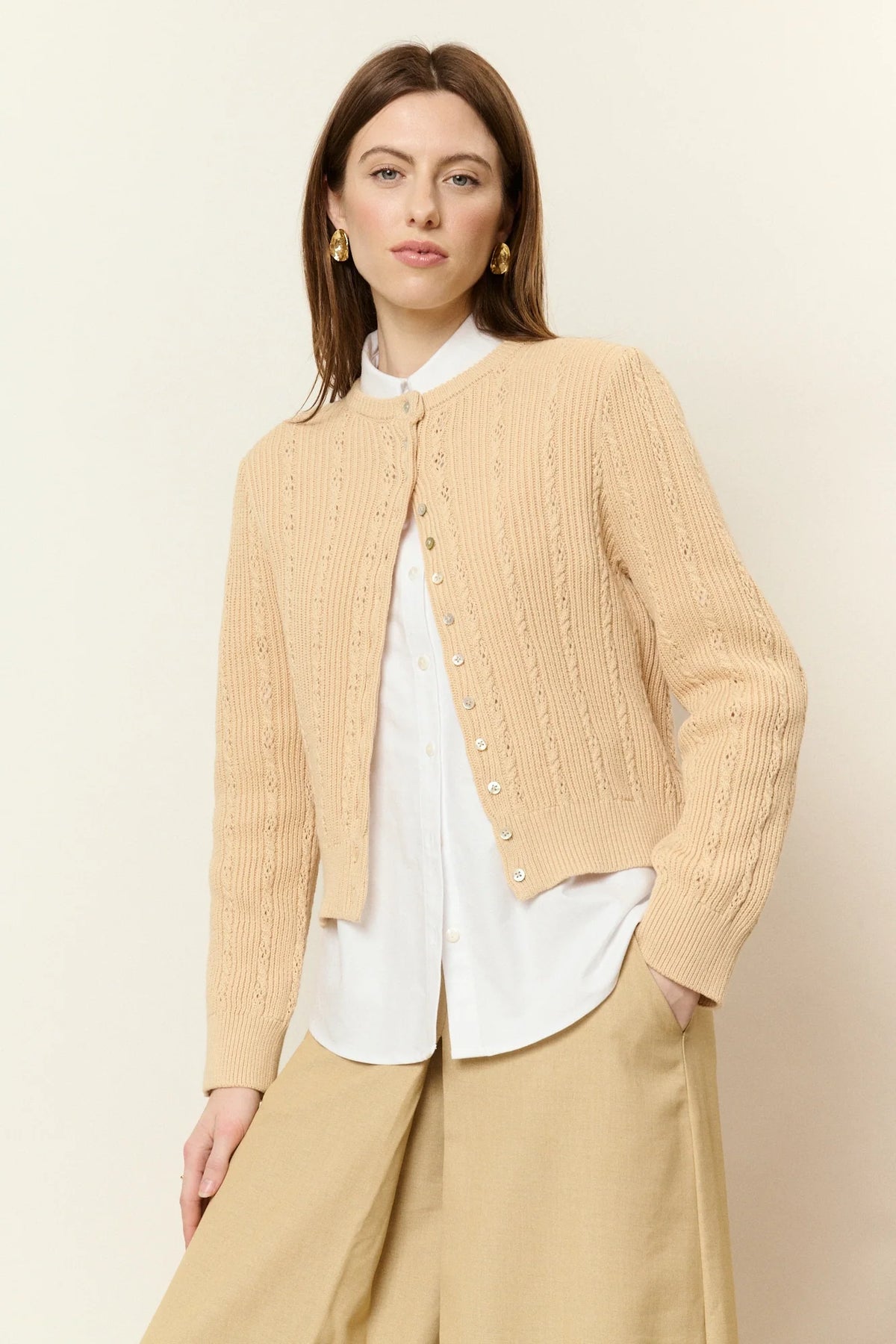 Femme portant le cardigan Gaétan en coton sable torsadé sur une chemise blanche