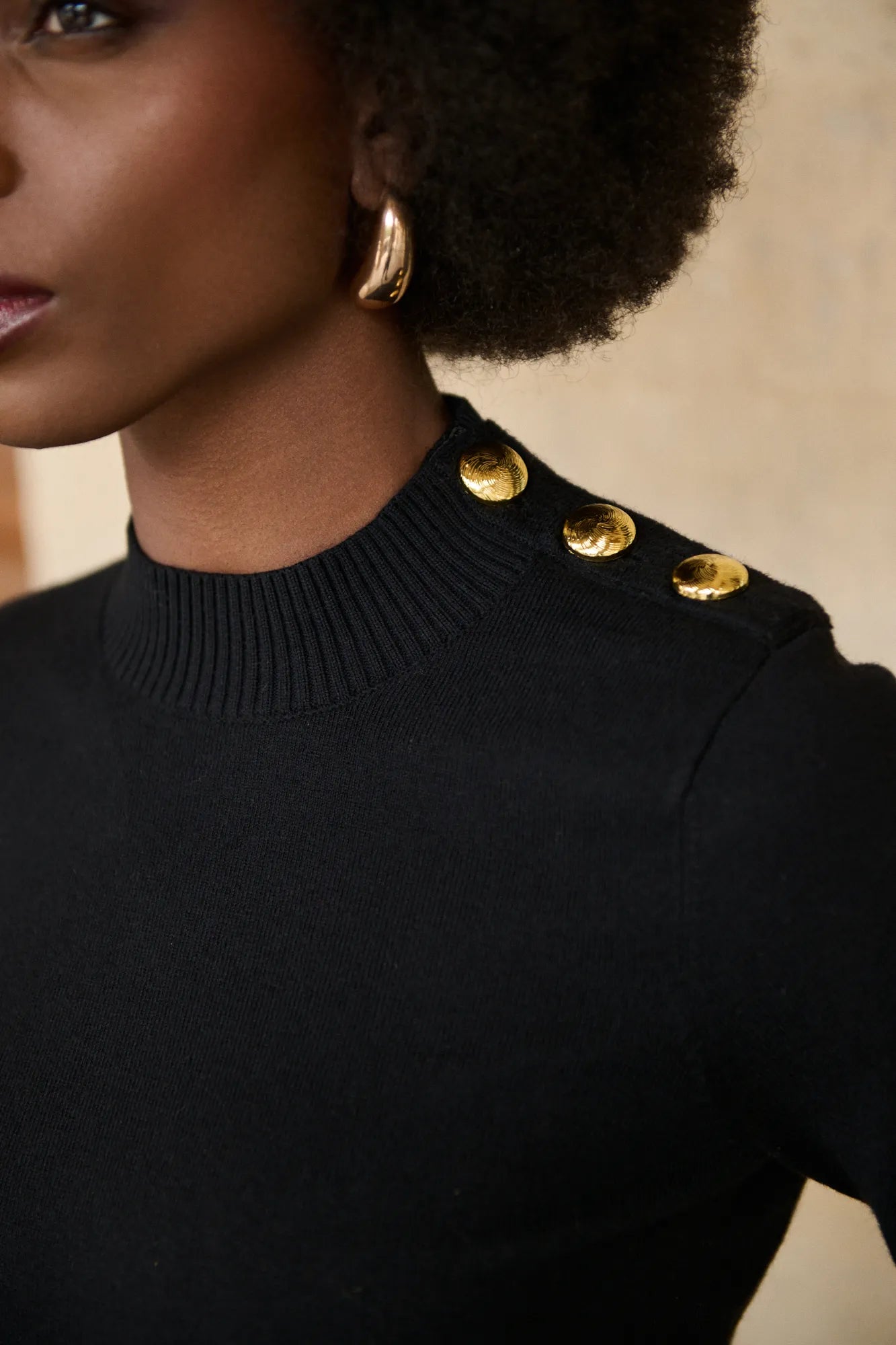 Détail des boutons métalliques dorés du pull Emma noir