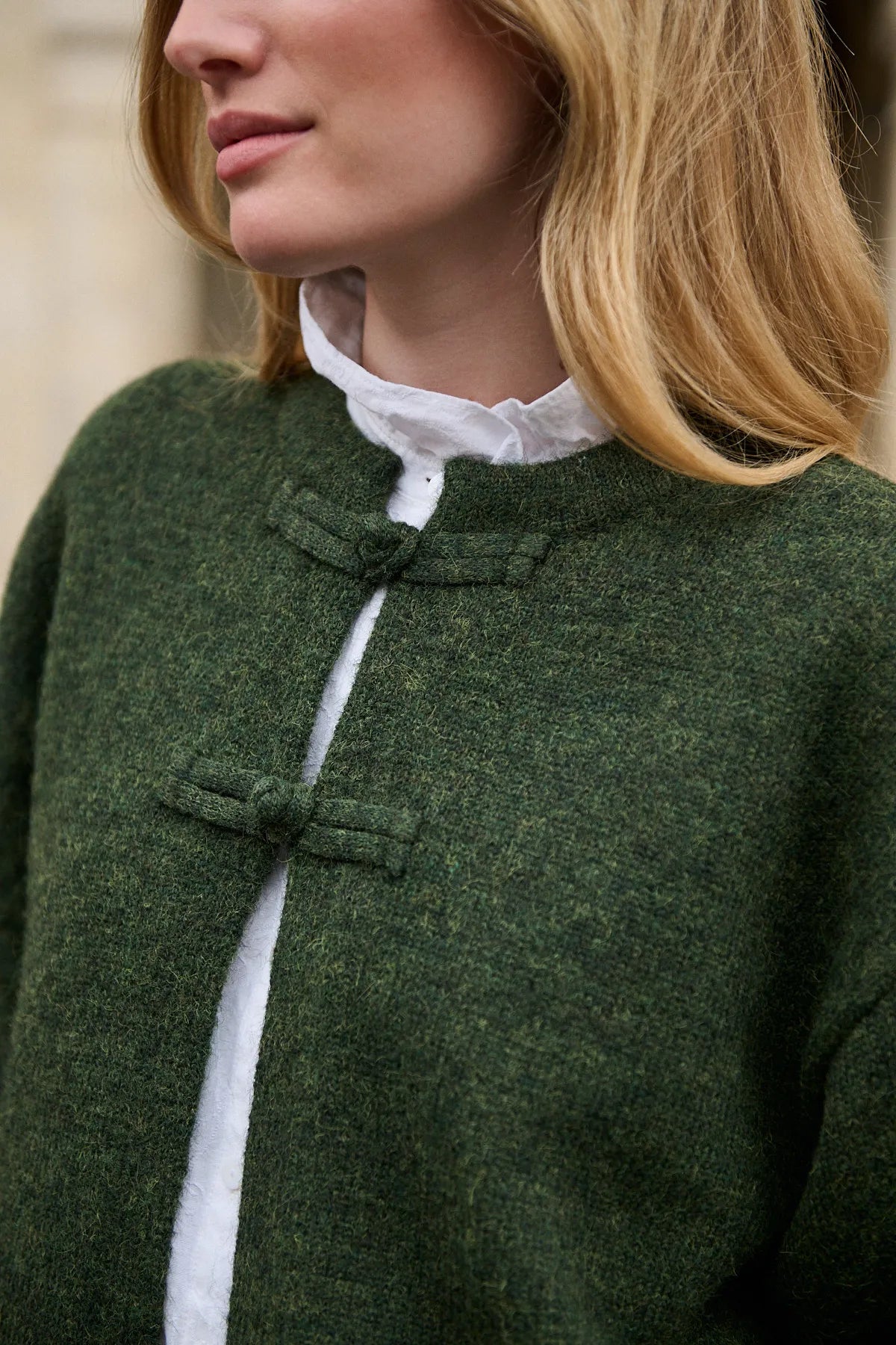 Détail des boutons de brandebourgs en maille et des boutons imitation corne du cardigan Alma olive