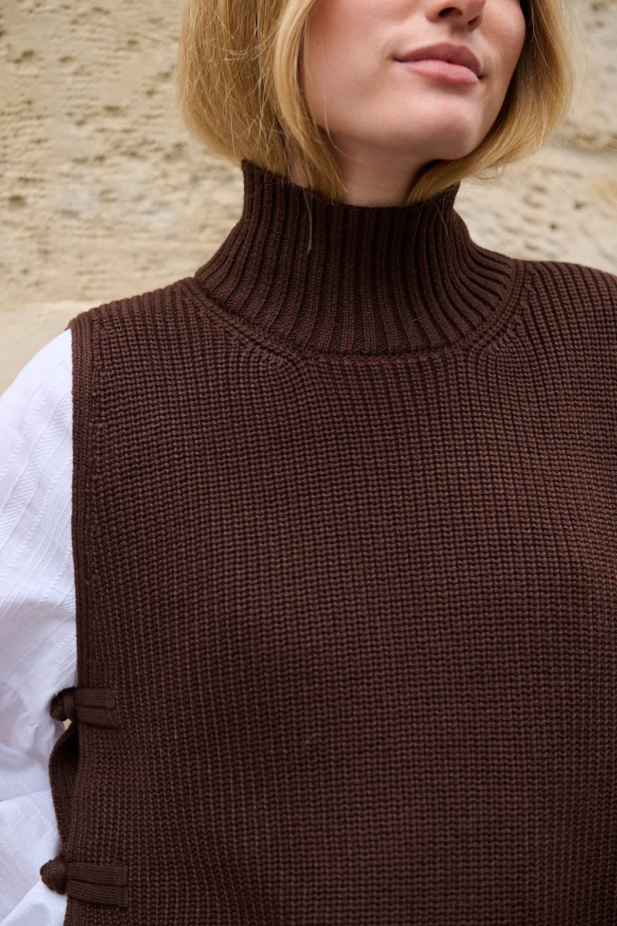 Mannequin portant le pull Théodore marron sans manches, détail encolure montante