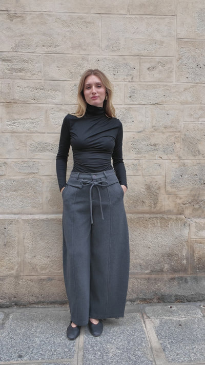 Mannequin présentant le pantalon Elias anthracite, coupe ample et jambe arquée